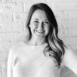 A portrait of Danielle Caswell. She is a white woman with long wavy hair and a light sweater