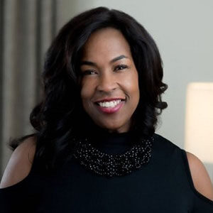 A portrait of Ramel Kelly. She is a black woman with long wavy hair and a black blouse