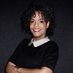 woman folding arms, wearing black shirt with white collar