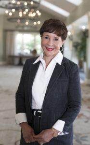 woman standing in black sport coat and white dress shirt