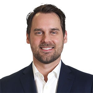 man in white dress shirt and black sport coat smiling 