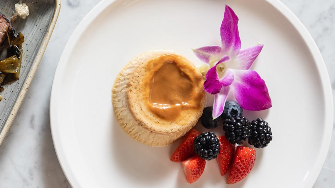 flan, strawberries, blueberries and flower