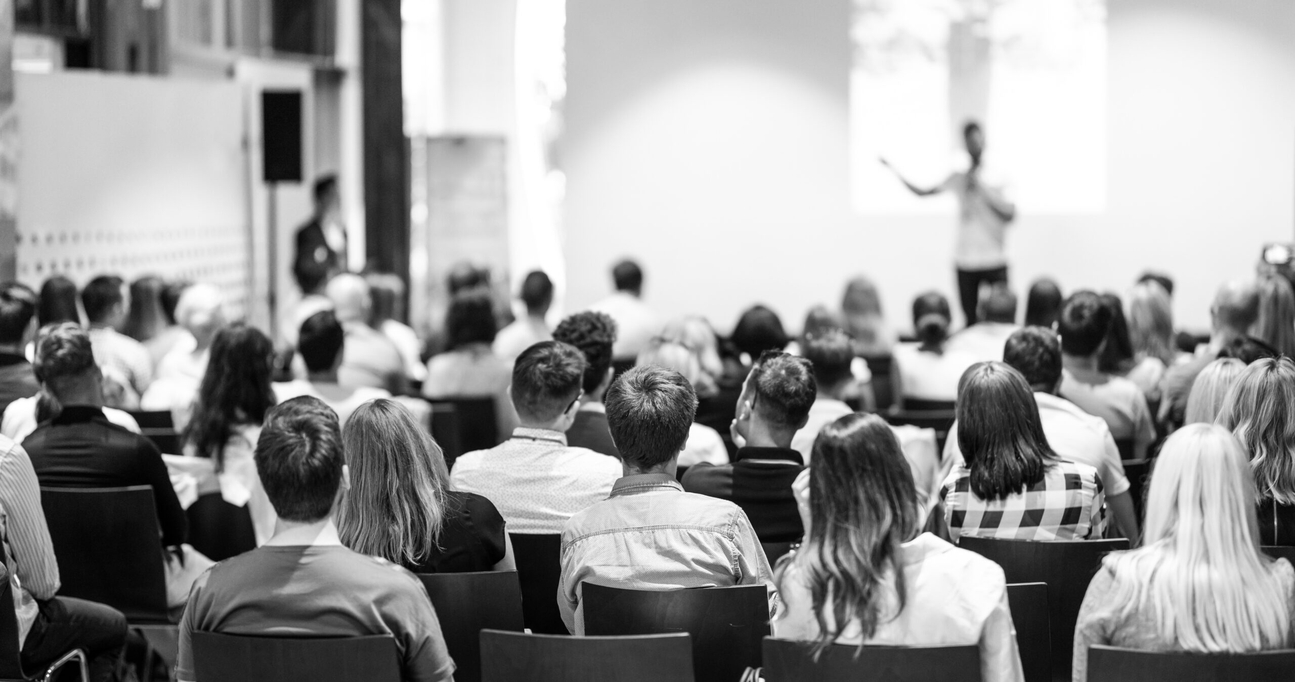 black and white image of conference room full of people