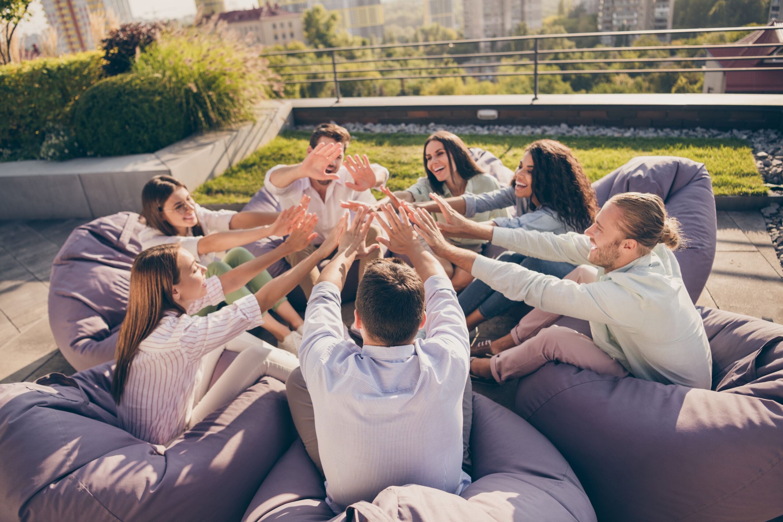 businesspeople sitting in circle high-fiving