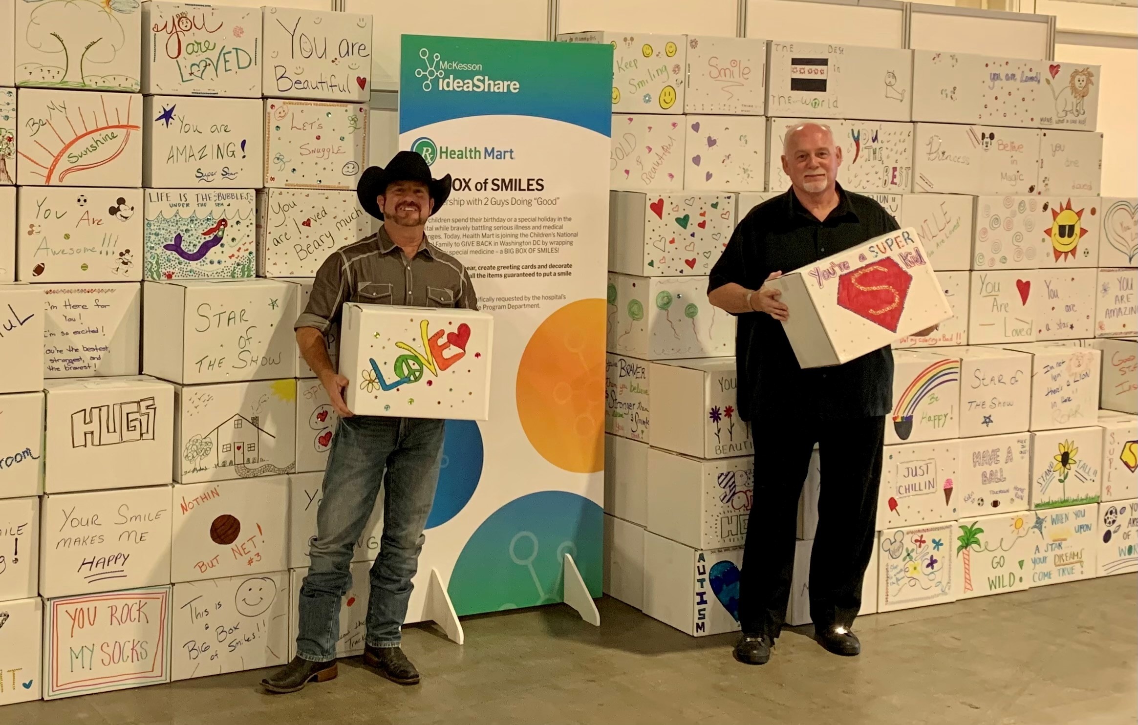 Rowan Pickering on left and Steven G. Foster on right holding boxes for kids