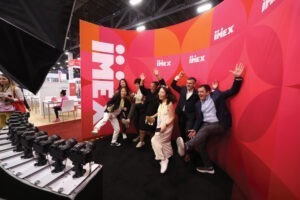 groups posing in front of rows of cameras