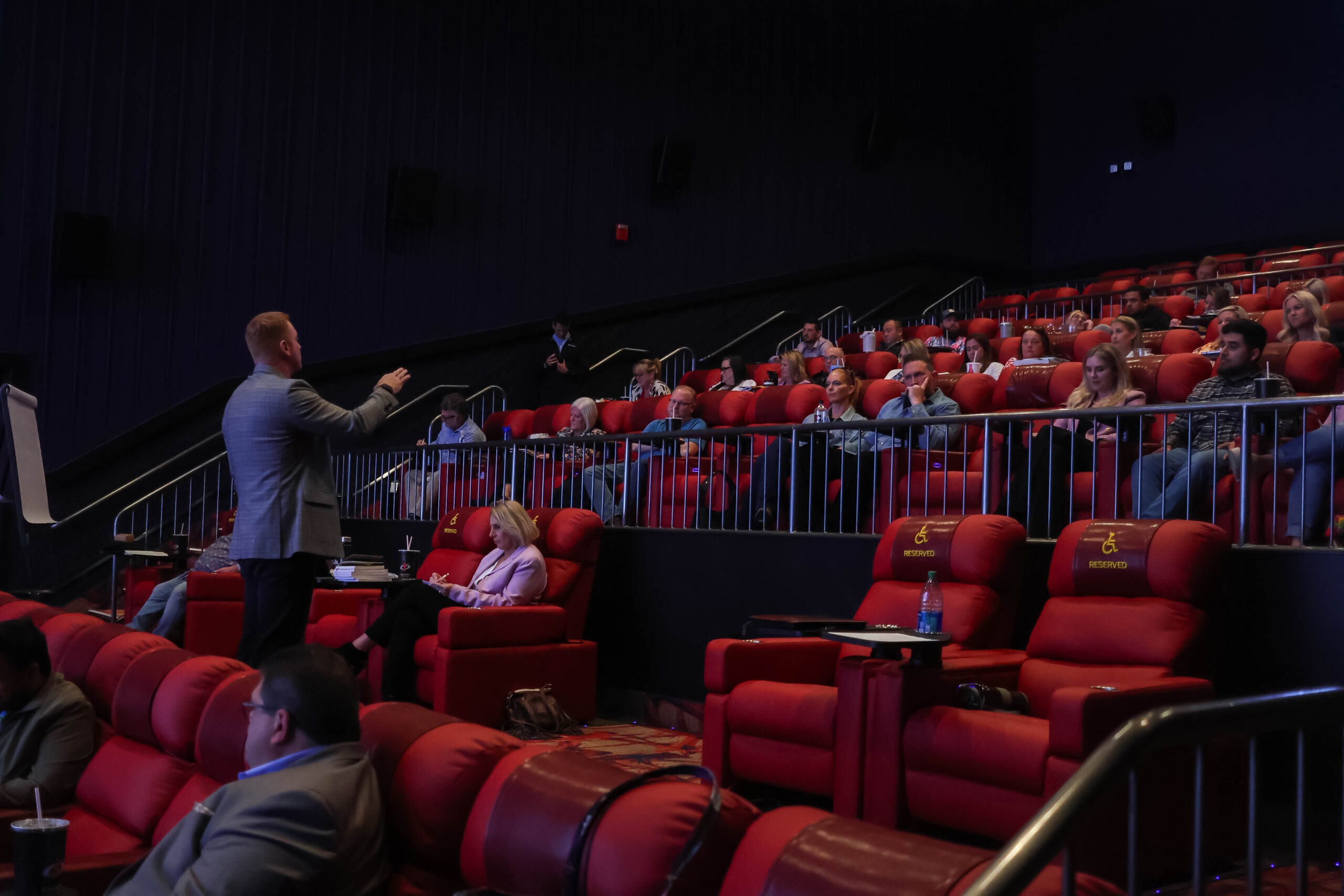 Attendees listening to speaker while sitting in theater