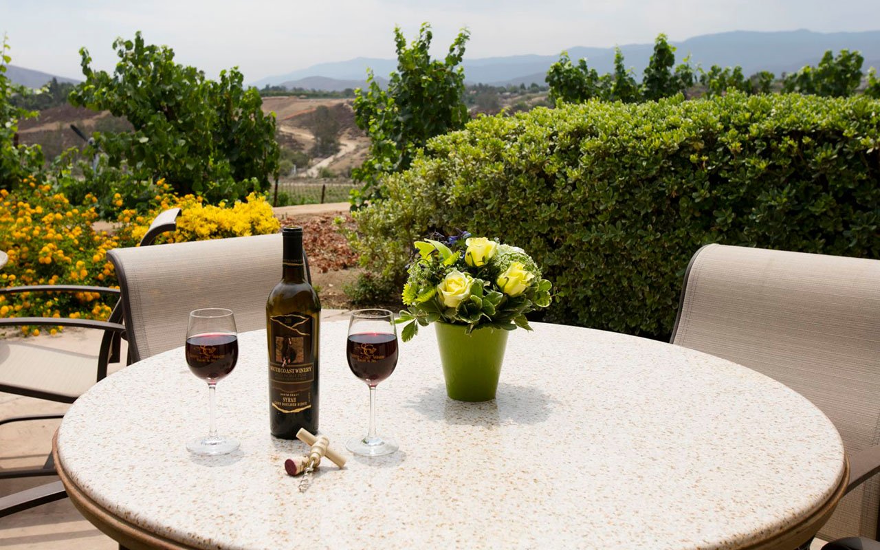 Wine bottle and glasses on table at outdoor space